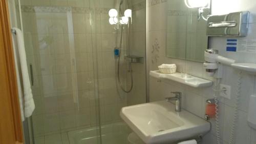 a bathroom with a shower and a sink at Hotel Bären in Sumiswald