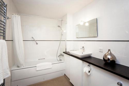 a white bathroom with a sink and a shower at The Walnut Tree Hotel in Bridgwater