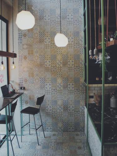a room with two chairs and a tiled wall at Sugar Ohana Poshtel in Kata Beach