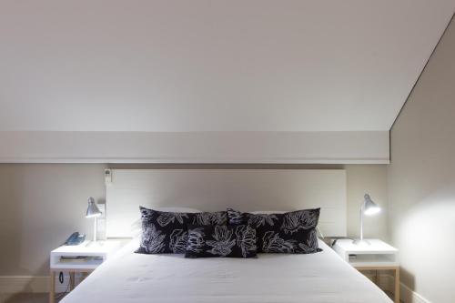 a bedroom with a white bed with two night stands at Quarry Lake Inn in East London