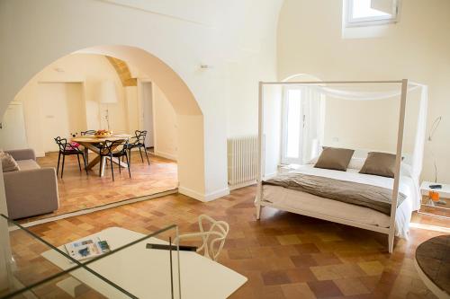 a bedroom with a bed and a dining room with a table at La Corte Dei Cavalieri in Matera