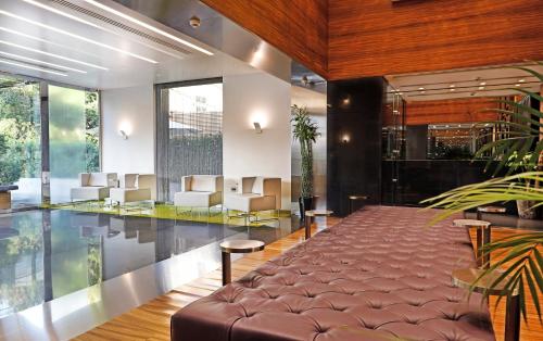 een lobby met een bank en stoelen in een gebouw bij Warwick Stone 55 Hotel Beirut in Beiroet