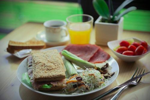 a plate of food with a sandwich and salad and fruit at Yulaikung B&B in Yongan
