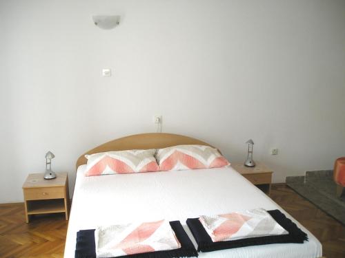 a bedroom with a white bed with two night stands at Apartment Any in Selce