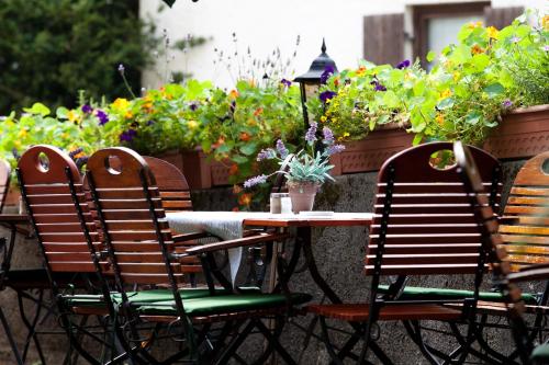 an outdoor table and chairs with flowers and plants at Gasthof - Hotel zur Post in Pöcking
