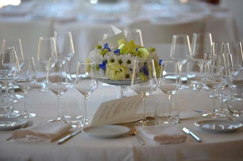a table with wine glasses and a bowl of flowers at Ristolocanda Grani Di Pepe in Flaibano
