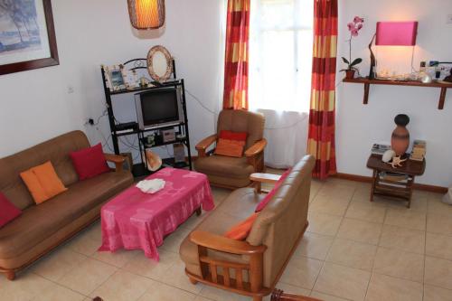 a living room with a couch and chairs and a tv at Flo Villa in La Gaulette
