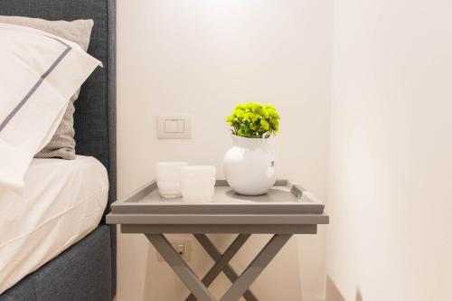 a table with two candles and a vase with a plant at Al Pescatore - B&B in Bari
