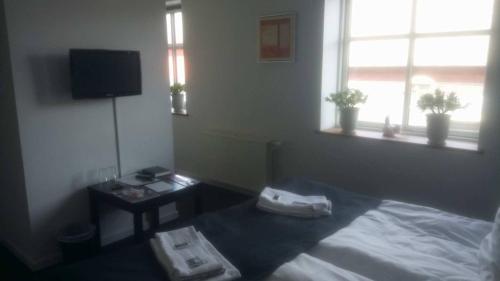 a bedroom with a bed and a desk and a window at Hotel Rødding in Rødding