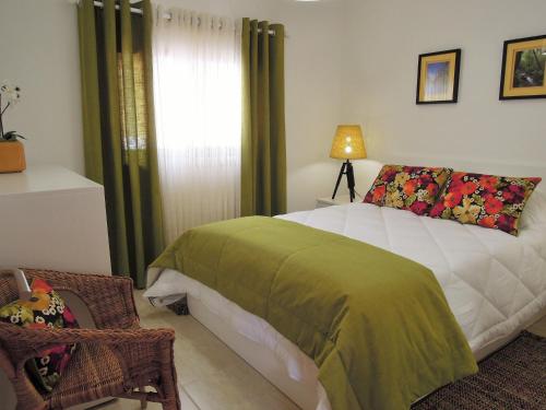 a bedroom with a bed with a green blanket on it at Casa do Professor in Albergaria-a-Velha