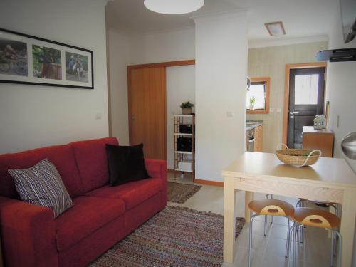 a living room with a red couch and a table at Casa do Professor in Albergaria-a-Velha