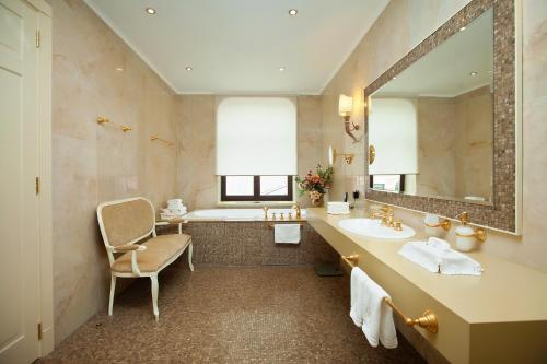 La salle de bains est pourvue d'une baignoire, d'un lavabo et d'un miroir. dans l'établissement Pontos Plaza Hotel, à Iessentouki