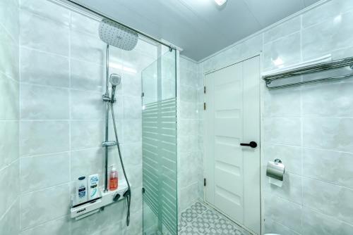 a shower with a glass door in a bathroom at Jeju Aurum in Seogwipo