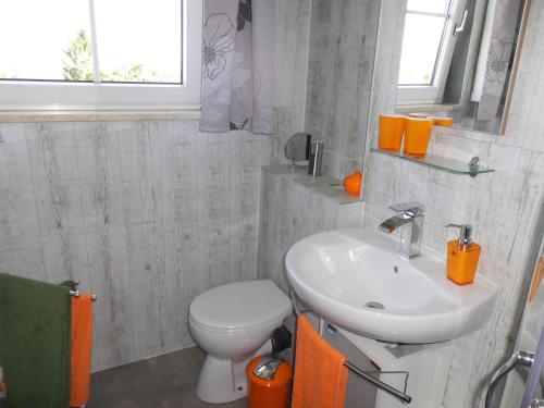 a bathroom with a white toilet and a sink at Ferienhaus Waldperle Harzblick in Wernrode