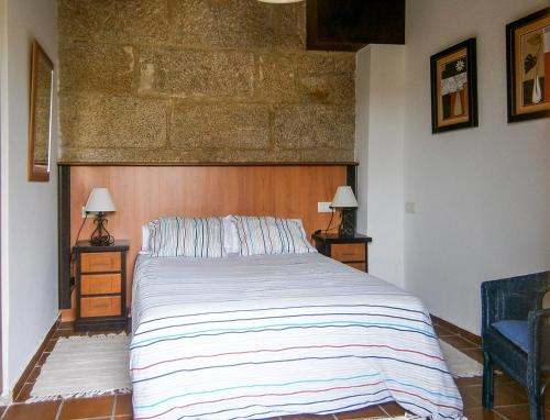 a bedroom with a large bed and two lamps at Casa Anceu ArchsenseApartments. in Anceu