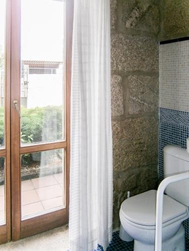 a bathroom with a toilet and a window at Casa Anceu ArchsenseApartments. in Anceu
