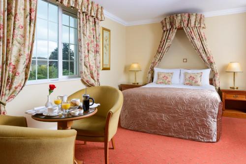 una camera d'albergo con un letto e un tavolo di Old Weir Lodge a Killarney
