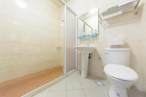 a bathroom with a shower and a toilet and a sink at Cat Mia Hostel in Hualien City