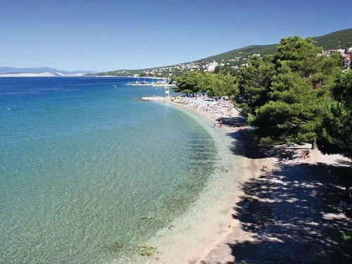 a beach with trees and people in the water at Lux dodo in Dramalj
