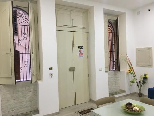 Habitación con mesa y 2 vidrieras. en Casa Vacanze Ortigia, en Siracusa