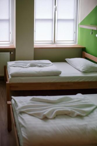 two beds in a room with two windows at Safestay Warsaw Old Town in Warsaw
