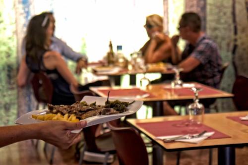 a person holding a plate of food and french fries at Hotel Aitana in Irún