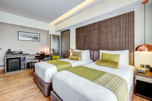 a hotel room with two beds and a desk at THE WAY Dhaka in Dhaka