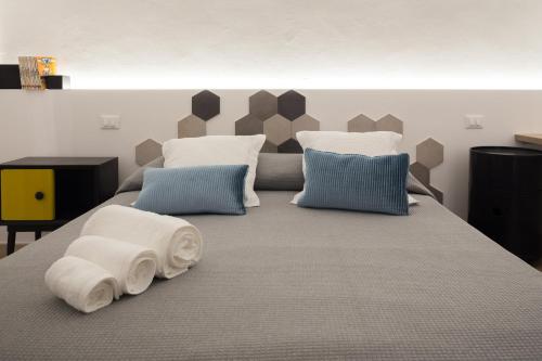 un grande letto con cuscini in una camera da letto di B22 - COMFY BEAUTIFUL LOFT a Monopoli