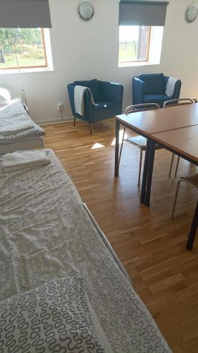 um quarto com duas camas e uma mesa e cadeiras em Stålemara Gård Krickan em Fågelmara
