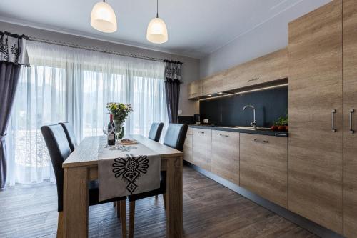 a kitchen and dining room with a table and chairs at Giewont Residence in Kościelisko