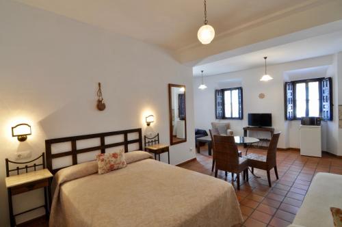 una camera da letto con un letto e una sala da pranzo di Apartamentos Plaza a Cordoba