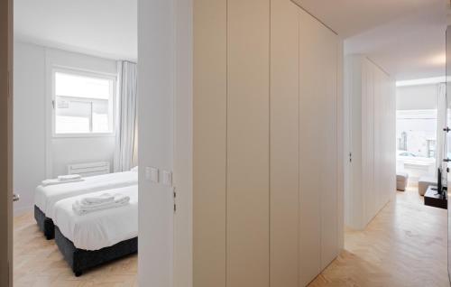 a white bedroom with a bed and a window at City Stays Sé Apartments in Lisbon