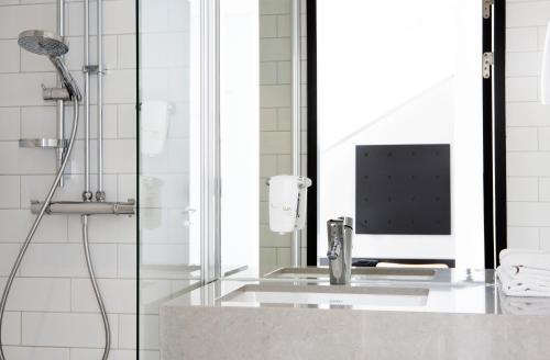 a bathroom with a shower with a computer on a counter at Comfort Hotel Xpress Stockholm Central in Stockholm