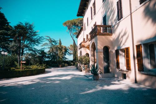 an empty street next to a building with a potted plant at Posta Donini 1579 - UNA Esperienze in San Martino in Campo