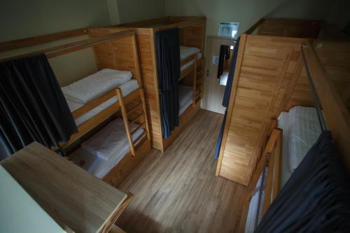a small room with bunk beds and a wooden floor at Safestay Warsaw in Warsaw