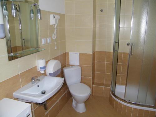 a bathroom with a toilet and a sink and a shower at Pokoje Gościnne O-ES-HA in Warsaw