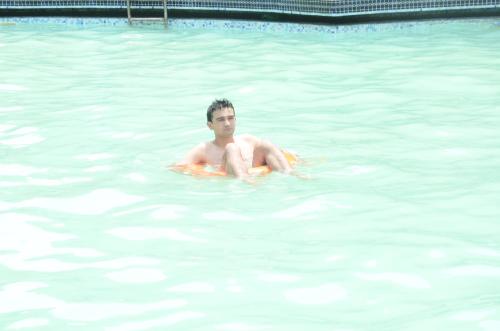 a man is sitting in a swimming pool at Magsons Resorts in Vrindāvan