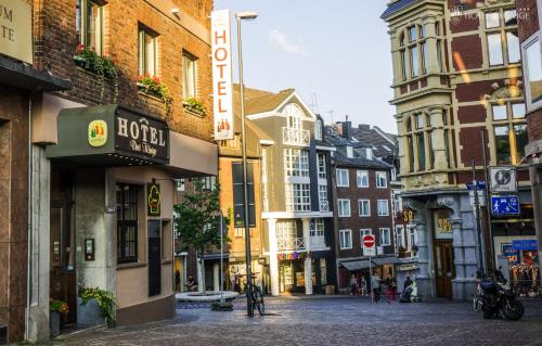 a city street with buildings and people walking on the street at Hotel 3 Könige in Aachen
