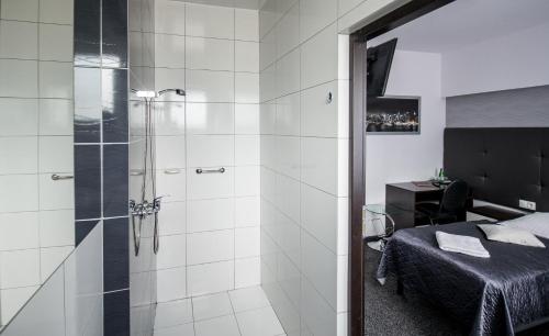 łazienka z prysznicem i łóżkiem w obiekcie Hotel Junior w Krakowie