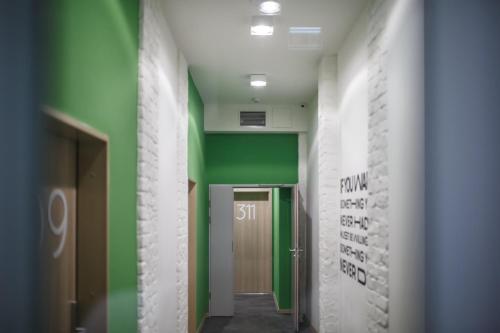 a hallway with green and white walls and a door at Safestay Warsaw Old Town in Warsaw