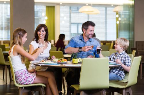 Vayamundo Oostende - Apartments في أوستند: مجموعة من الناس يجلسون على طاولة في مطعم