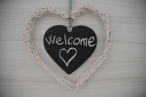 a black heart with welcome written on it on a chain at Mary Apartments in Brenzone sul Garda