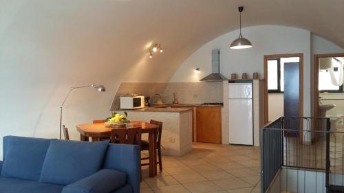 - un salon et une cuisine avec une table et un canapé bleu dans l'établissement Dedalus, à Taormine