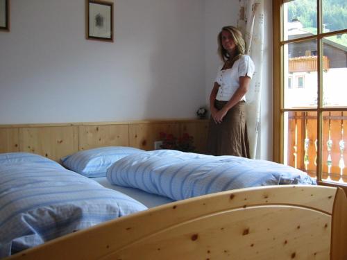 a woman standing in a room with two beds at Nature Residence Telfnerhof in Laion