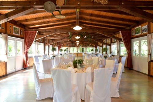 a banquet hall with white tables and white chairs at Waldhotel Eiche in Burg