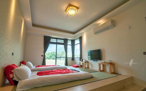 a bedroom with three beds in a room at Yulaikung B&B in Yongan