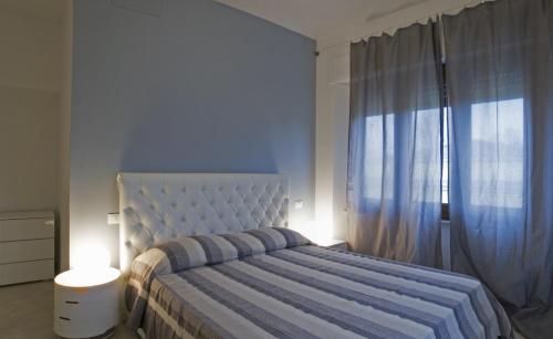 a bedroom with a bed and a large window at Appartmento Villa Oasis in Forte dei Marmi