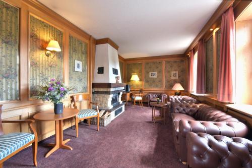 a waiting room with a couch and a fireplace at Waldhotel Eiche in Burg