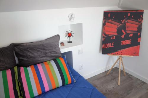 ein Schlafzimmer mit einem Bett und einem Plakat an der Wand in der Unterkunft Lisbon Beach Apartments 5 in Costa da Caparica