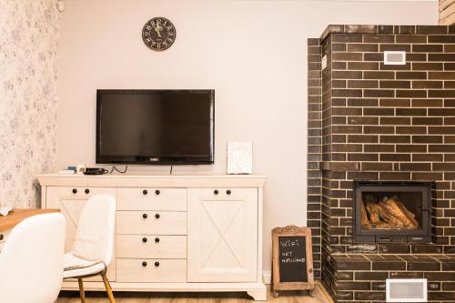 a living room with a tv and a fireplace at Paju Apartement with Sauna in Võru